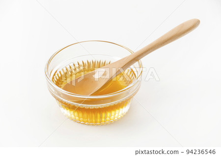 Honey and spoon in a glass bowl 94236546