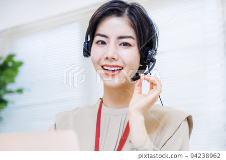 在辦公室工作時戴耳機的年輕女性 94238962
