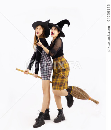 Halloween concept, young asian women wearing witch hat holding broom and shopping bags posing on white background. 94239136