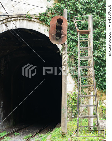 Entrance to a dark railway tunnel. Rusty railway abandoned traffic light. Entrance to a dark railway tunnel. Rusty railway abandoned traffic light. 94239618