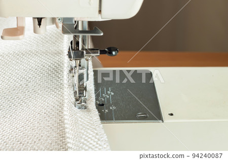 sewing machine. the process of sewing a decorative cord of white fabric. sewing machine. the process of sewing a decorative cord of white fabric. 94240087