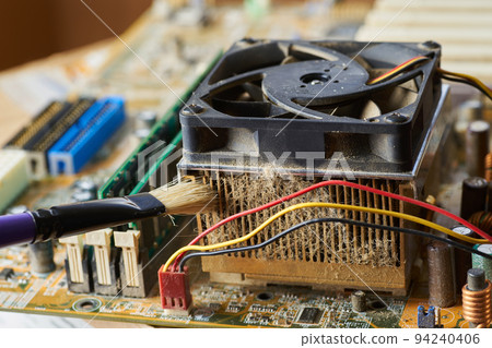 Brush cleaning an old computer board from dust and dirt. Close-up. Brush cleaning an old computer board from dust and dirt. Close-up. 94240406