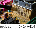 Brush cleaning an old computer board from dust and dirt. Close-up. 94240416