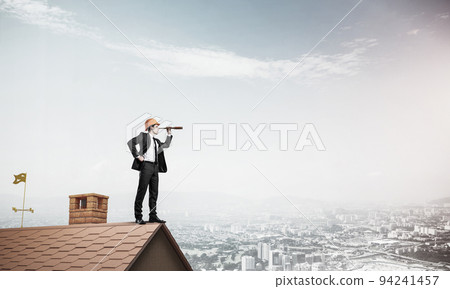 Engineer man standing on roof and looking in spyglass. Mixed med 94241457