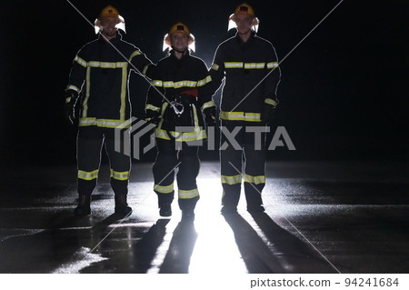 Portrait of a group of firefighters standing and walking brave and optimistic with a female as team leader. Portrait of a group of firefighters standing and walking brave and optimistic with a female as team leader. 94241684
