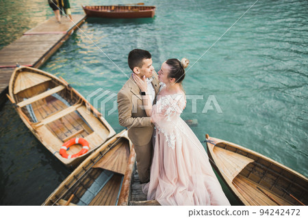 Wedding couple on the nature is hugging each other. Beautiful model girl in white dress. Man in suit 94242472