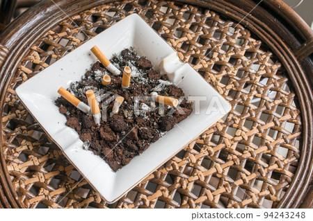 Ashtray and smoke cigarettes on wooden table. 94243248