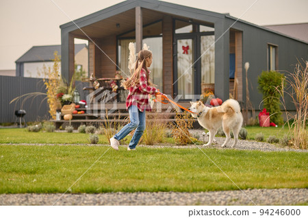Teen spending time with her lovely dog outdoors Teen spending time with her lovely dog outdoors 94246000