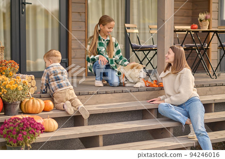 Female parent spending time with her kids on the veranda 94246016