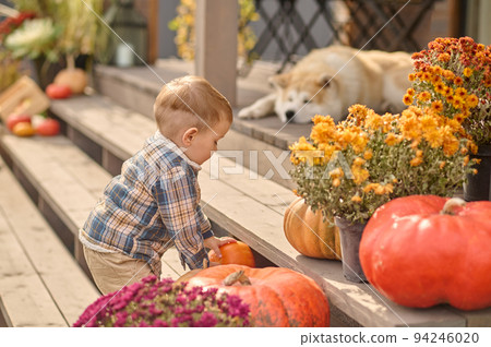 Child playing on the stairs outdoors while his dog sleeping 94246020