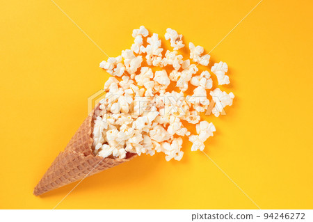 Waffle Cone with Salted Popcorn on yellow background. Snack concept 94246272