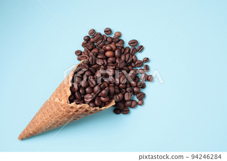 Waffle Cone with Coffee Beans on blue background Waffle Cone with Coffee Beans on blue background 94246284