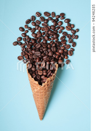 Waffle Cone with Coffee Beans on blue background Waffle Cone with Coffee Beans on blue background 94246285
