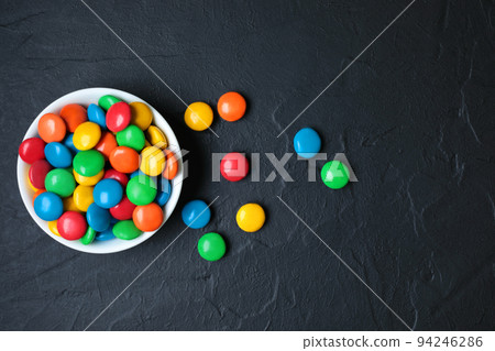 Vessel with Color Candies on black concrete background Vessel with Color Candies on black concrete background 94246286