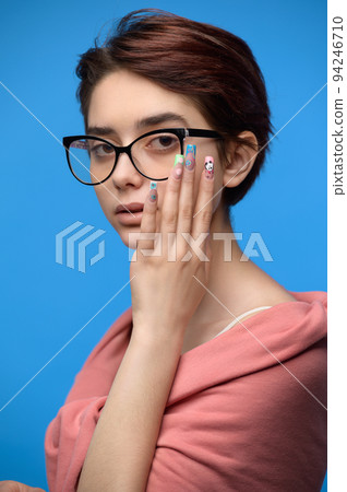 Cute female student with short haircut and extravagant nail art Cute female student with short haircut and extravagant nail art 94246710