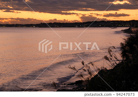 Waves rushing to the sea at dusk 94247073