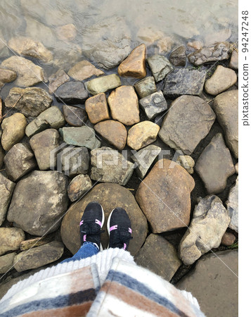 Woman standing near River Stones 94247248