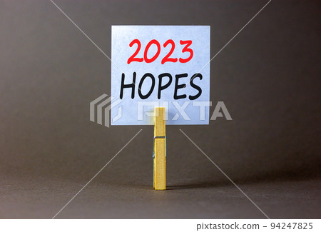 2023 Hopes symbol. White paper with words 2023 Hopes, clip on wooden clothespin. Beautiful grey table grey background. Business and 2023 hopes concept. Copy space. 2023 Hopes symbol. White paper with words 2023 Hopes, clip on wooden clothespin. Beautiful grey table grey background. Business and 2023 hopes concept. Copy space. 94247825