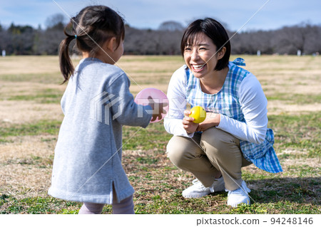 Kindergarteners and nursery teachers playing on the lawn square in the park 94248146