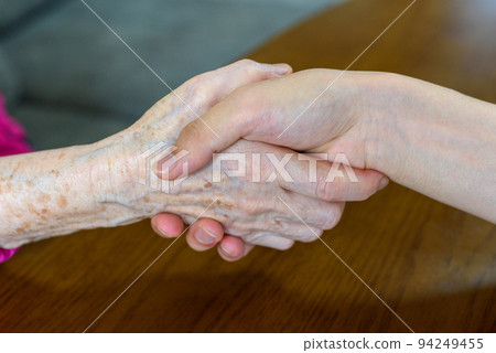 A young man and an old man holding hands 94249455