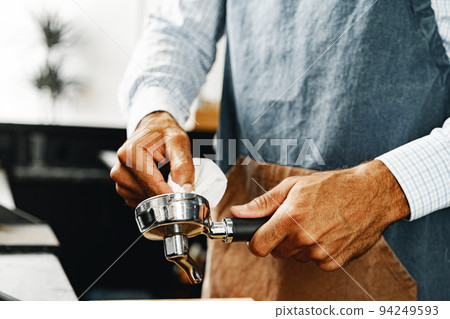 Unrecognizable man barista preparing coffee on professional coffee machine 94249593