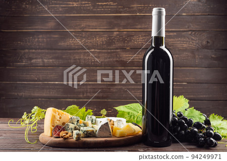 Wine bottle and grape on wooden table 94249971