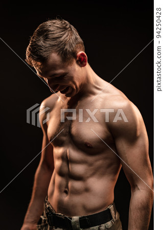 Studio shot of muscular topless military man on black background Studio shot of muscular topless military man on black background 94250428