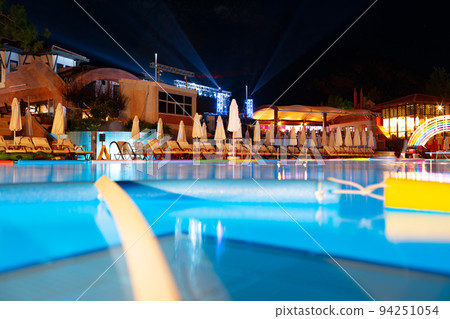 Swimming pool at a luxury resort at night time 94251054
