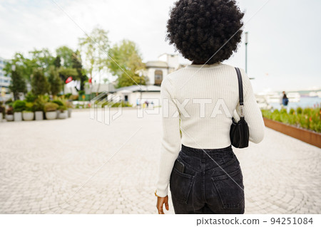 Back view of african woman walking in city Back view of african woman walking in city 94251084