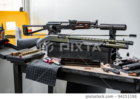 Shotgun rifle with cartridges on table in a weapon workshop 94251198