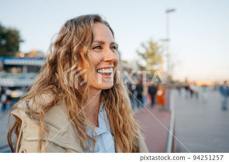 Portrait of a charming young woman posing for camera in the city Portrait of a charming young woman posing for camera in the city 94251257