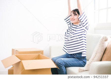 A woman taking a break with a smile during moving work A woman taking a break with a smile during moving work 94251337