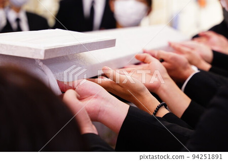 Relatives closing coffin lid 94251891