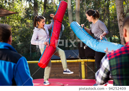 Female friends fighting by inflatable logs 94252409