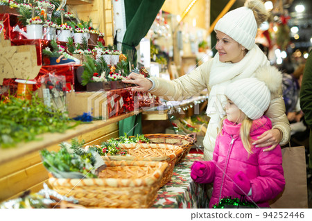 Young girl and her mother are buying Christmas ornamentals in the market outdoor 94252446