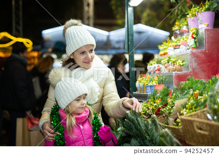 Cheerful girl with mom choosing New Year tree 94252457