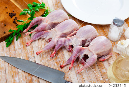 Fresh raw meat quails ready for cooking on slate board Fresh raw meat quails ready for cooking on slate board 94252545