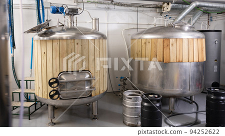 Interior of small brewery with tanks for beer fermentation and kegs Interior of small brewery with tanks for beer fermentation and kegs 94252622
