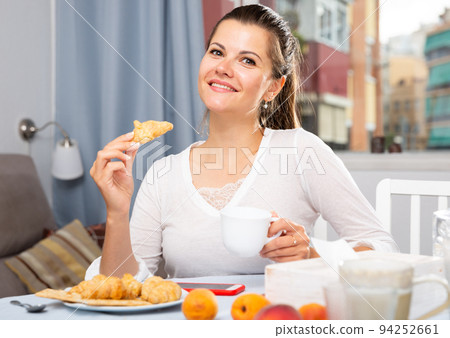 Woman enjoying coffee with pastry Woman enjoying coffee with pastry 94252661