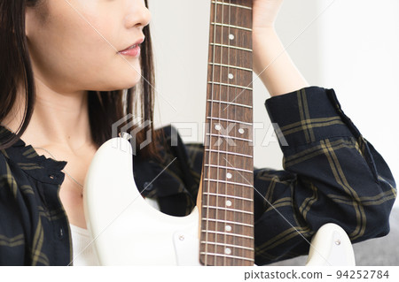 坐在沙發上彈吉他的女人 坐在沙發上彈吉他的女人 94252784