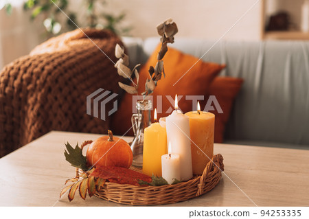 Autumn interior and festive mood with burning candles and pumpkin 94253335