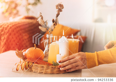Autumn interior and festive mood with burning candles and pumpkin 94253336