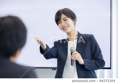 Seminar A woman speaking with a microphone Seminar A woman speaking with a microphone 94255264