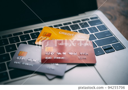 Close up multiple credit cards placed on the laptop. online shopping payment and retail concepts. mockup and fake credit card. 94255706