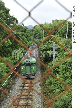 Railroad track and train on fence background 94256200