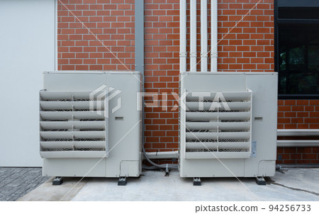 Air compressor or condenser unit installed outside building. 94256733