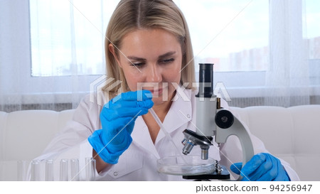 professional scientist takes a sample for a medical experiment. A research chemist works in a professional scientist takes a sample for a medical experiment. A research chemist works in a 94256947
