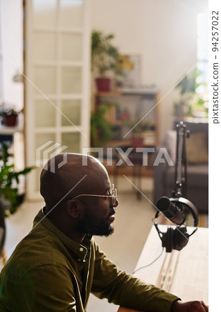 Side view of young African American male host talking in microphone Side view of young African American male host talking in microphone 94257022