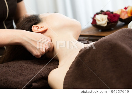 A woman is getting a neck massage. 94257649