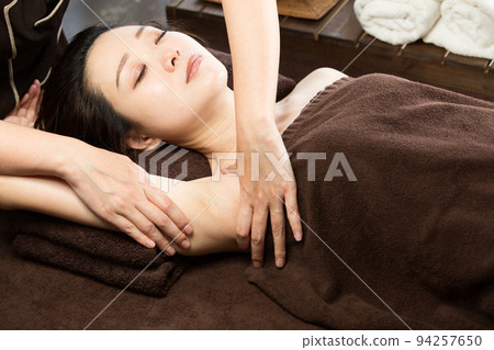 A woman is getting an armpit massage. 94257650